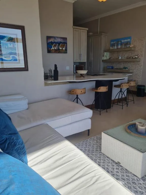 Open-plan lounge with sofa, kitchen counter, and bar seating area