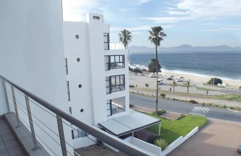 Beachfront view with ocean, mountains, and palm trees from property