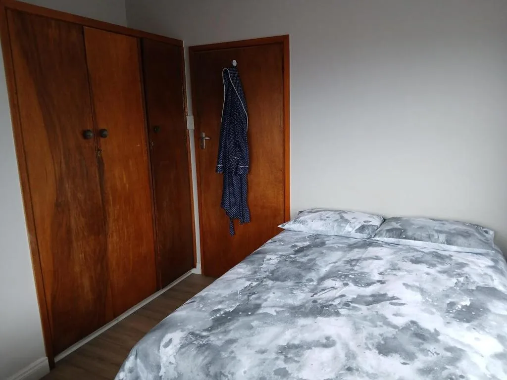 Bedroom with double bed, wooden wardrobes, and white walls