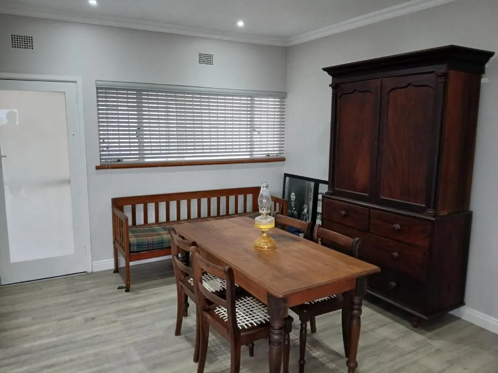 Wooden dining table with chairs and bench seating in bright room