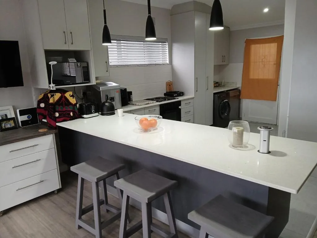 Modern kitchen with white cabinetry, island seating, and stainless steel appliances