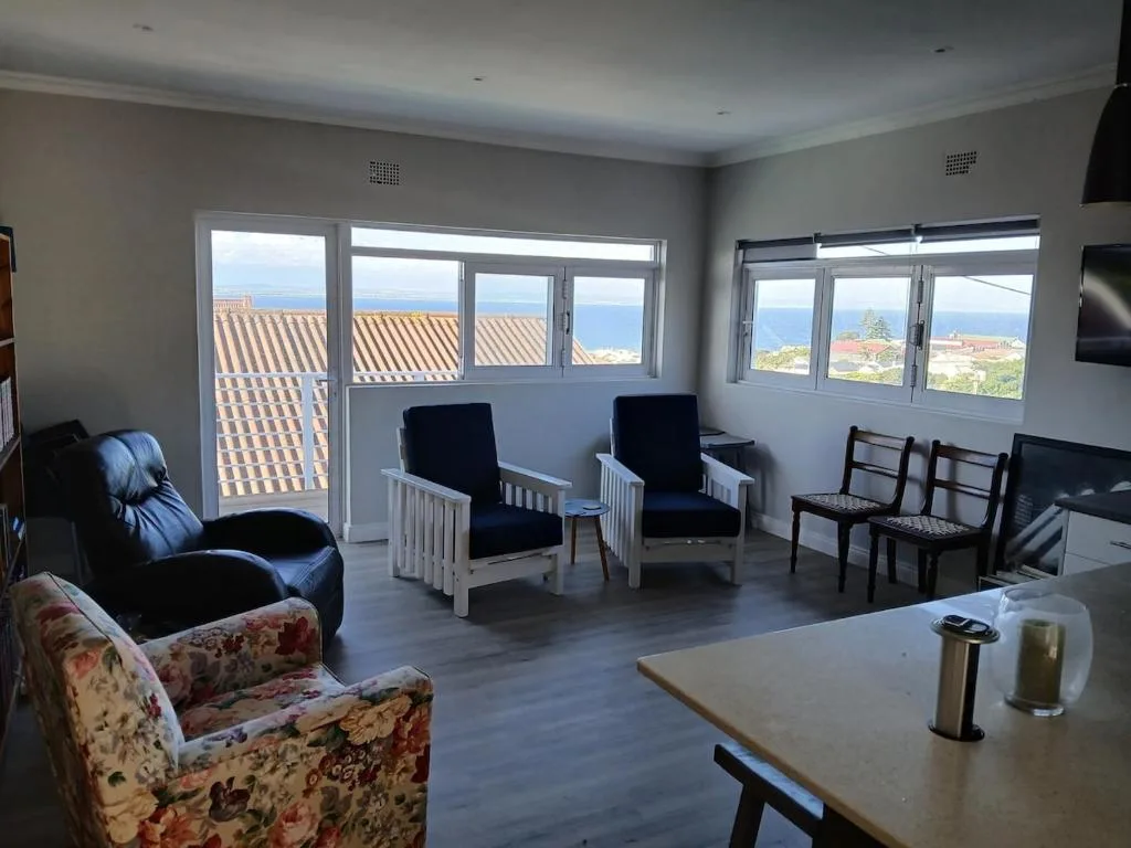 Spacious lounge with multiple seating areas and coastal views through large windows