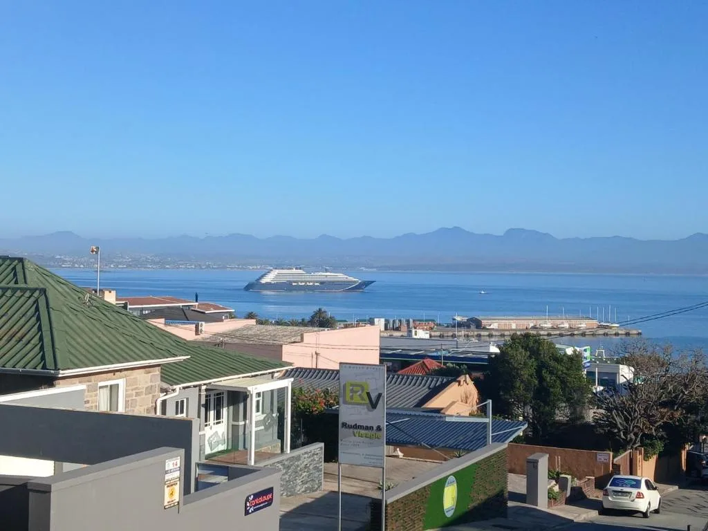 Ocean vista with cruise ship and mountains across the bay