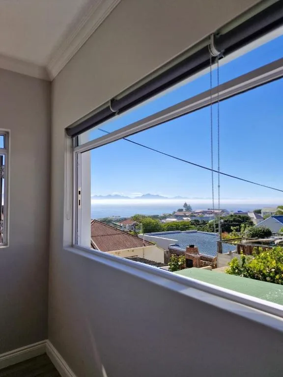 Coastal lagoon and mountain vista through large interior window frame