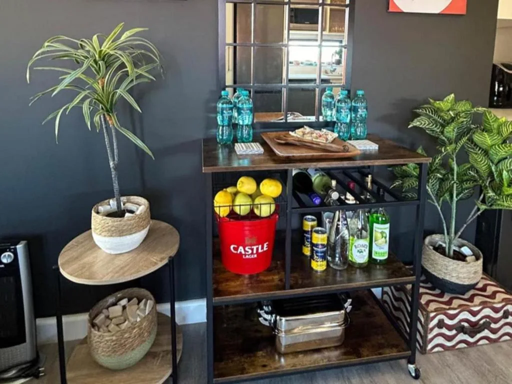 Stylish kitchenette bar with plants, bottles, and decorative storage shelving