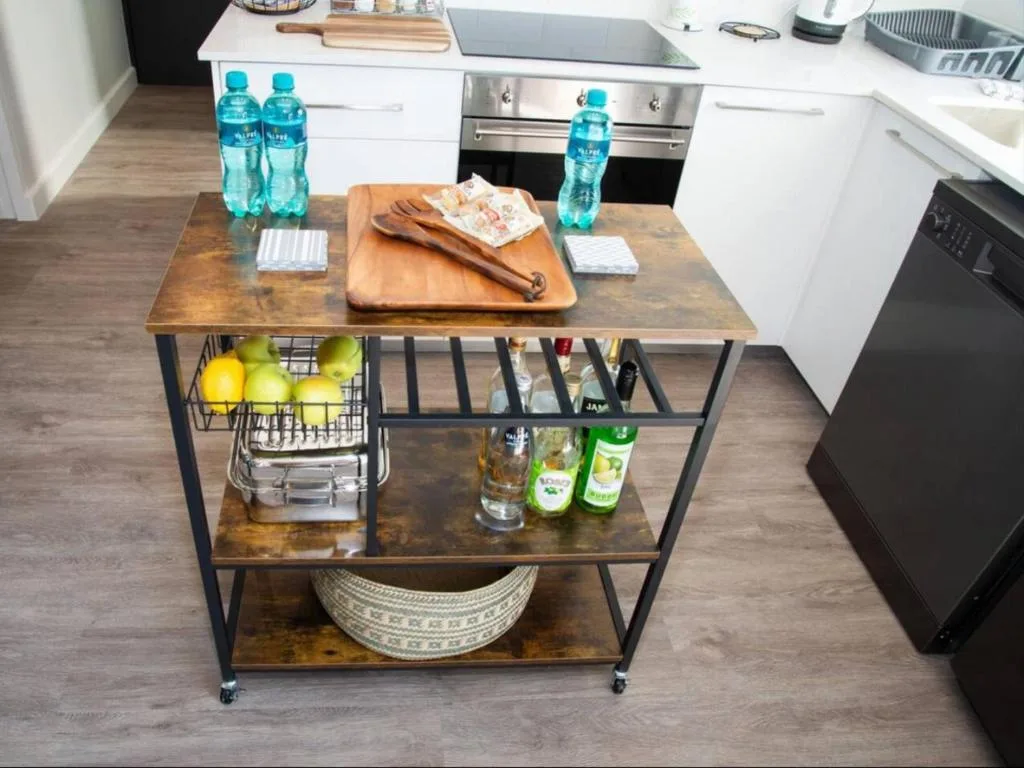 Modern kitchen with stainless steel appliances and wooden island cart with storage