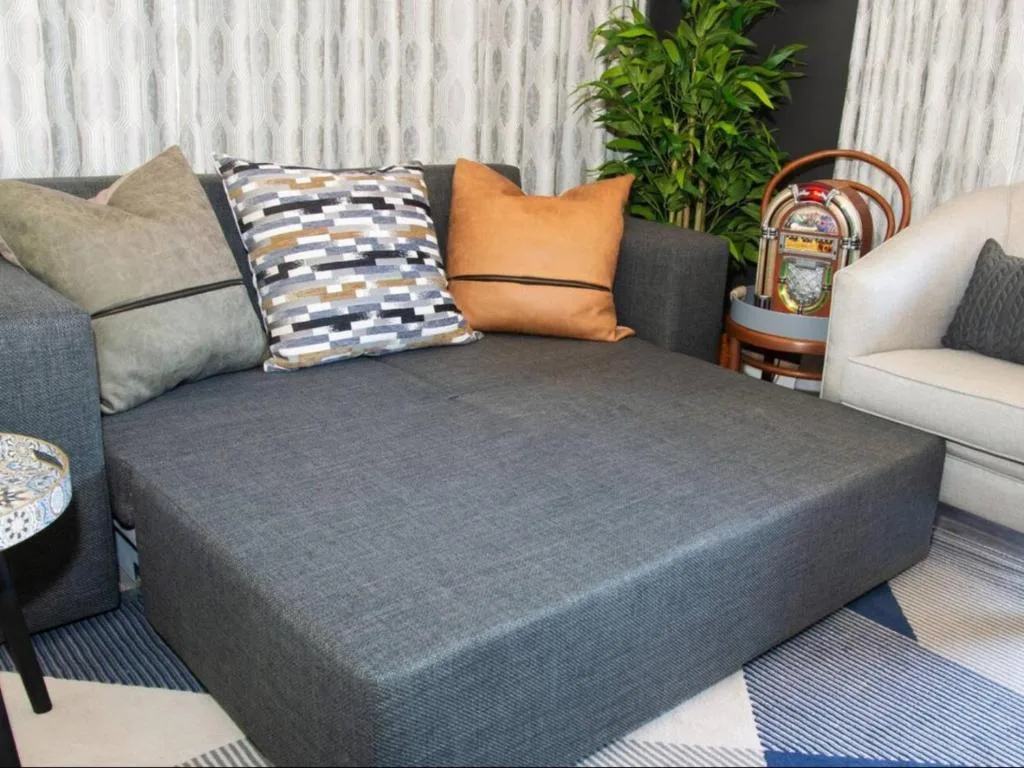 Modern living room with gray sectional sofa, decorative pillows, and potted plant