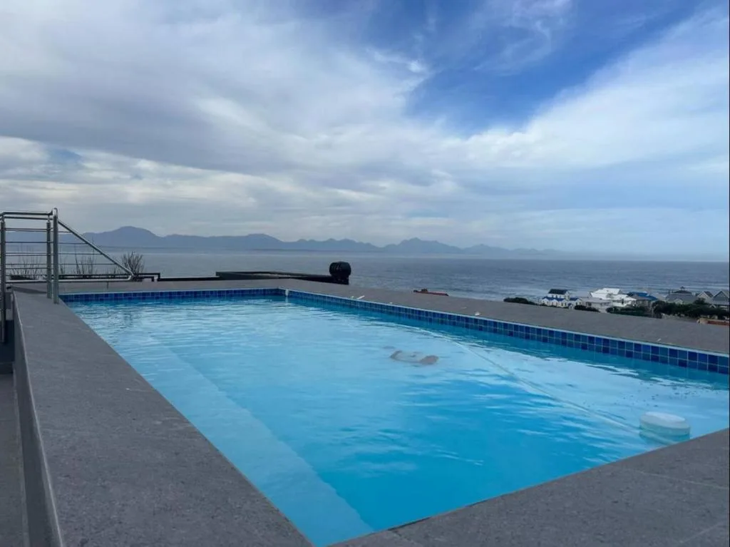 Sparkling swimming pool overlooking ocean and mountains on Garden Route