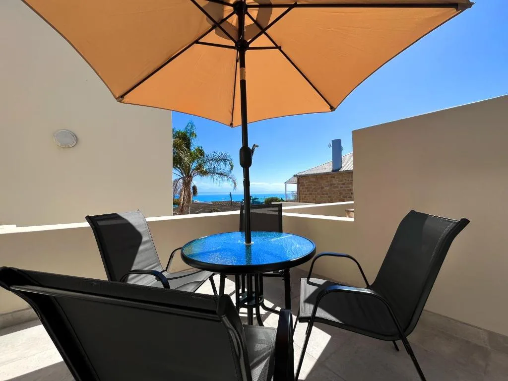 Shaded outdoor seating area with ocean views and palm trees beyond