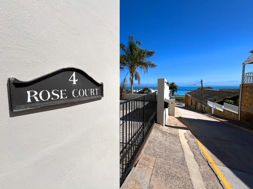 Property entrance with Rose Court sign and ocean view beyond