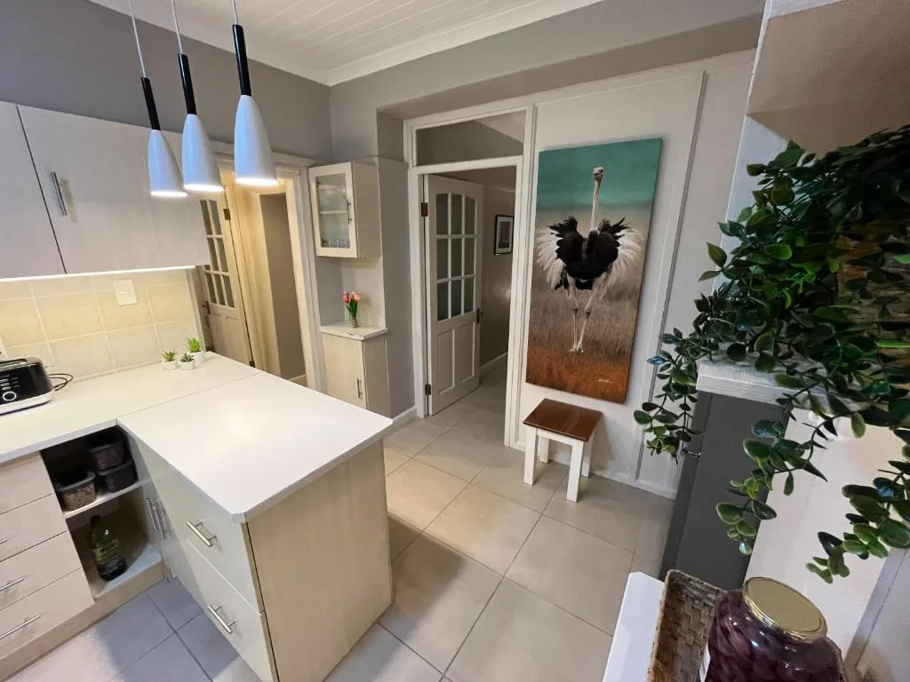 Modern white kitchen with island counter, pendant lights, and open-plan layout