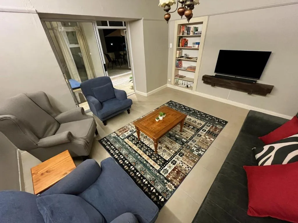 Modern living room with comfortable seating, TV, and glass sliding door to balcony