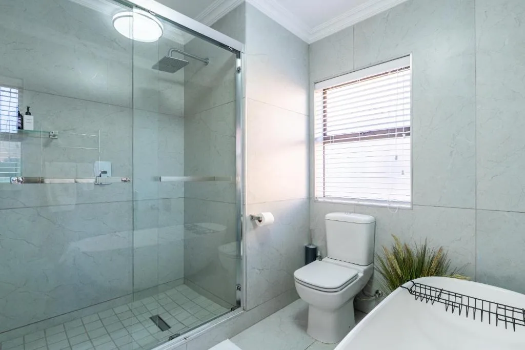 Modern bathroom with frameless glass shower enclosure and white toilet
