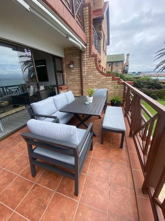 Outdoor terrace with comfortable seating and ocean view beyond
