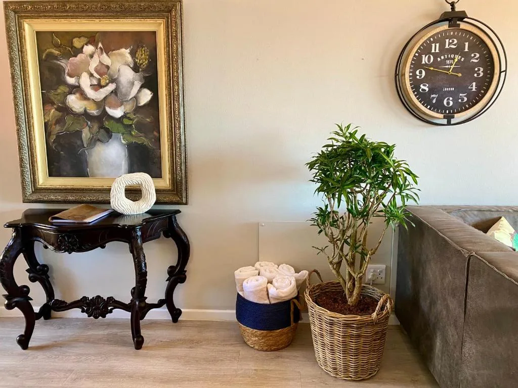 Elegant lounge decor with ornate table, framed floral art, and potted plant