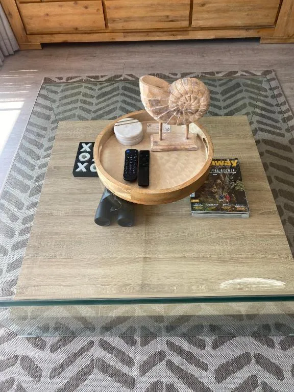 Coffee table styled with decorative items, remote control, and magazines