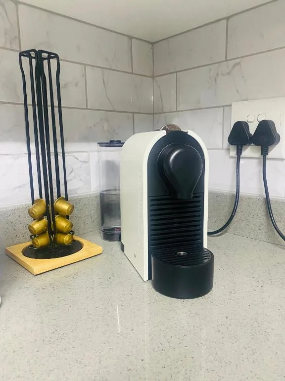 Kitchen counter with coffee machine, golden capsule holder, and accessories