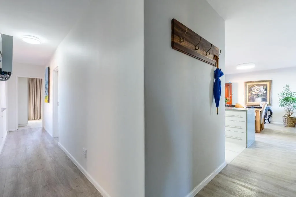 Bright hallway with wooden coat rack and potted plant decor