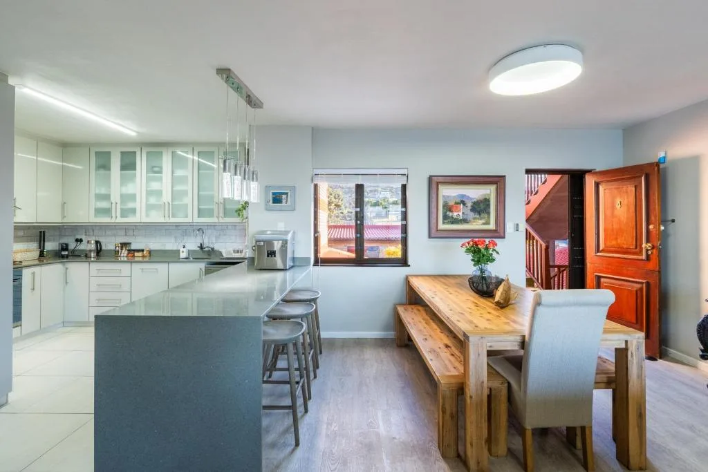 Open-plan dining area with wooden table, bench seating, and garden views