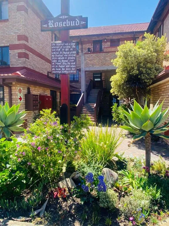 Brick building entrance with manicured gardens and agave plants