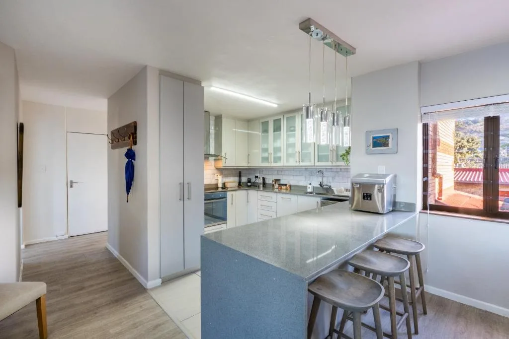 Modern kitchen with white cabinetry, island seating, and stainless steel appliances