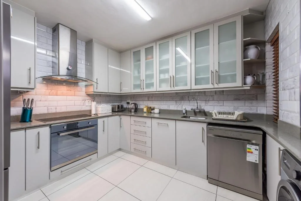 Modern kitchen with white cabinetry, stainless steel appliances, and subway tile backsplash
