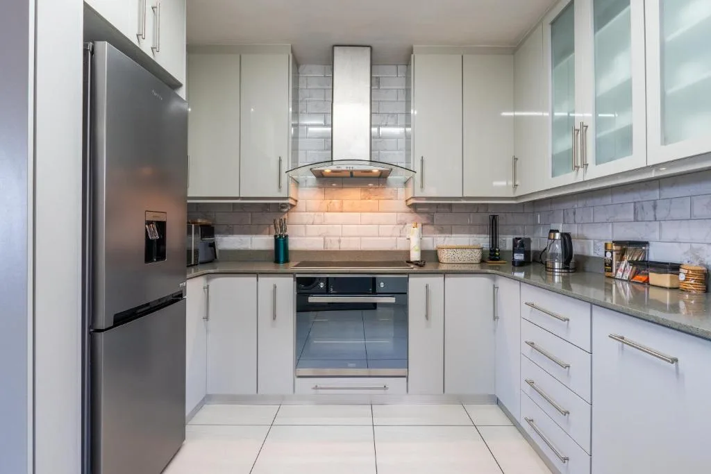 Modern white kitchen with stainless steel appliances and subway tile backsplash