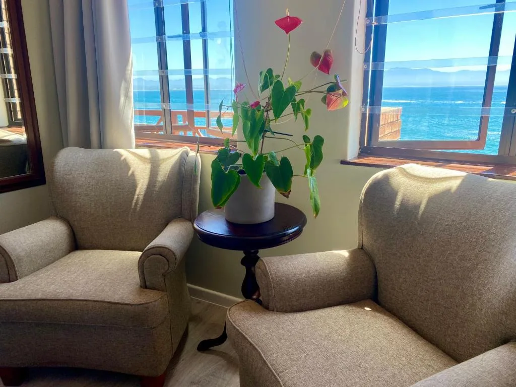 Bright lounge with upholstered chairs and ocean view windows