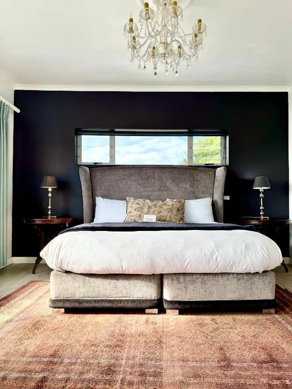 Elegant master bedroom with upholstered headboard and crystal chandelier
