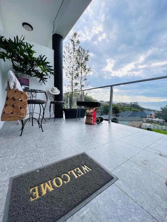 Modern patio with tiled flooring, seating, black chimney, and valley views