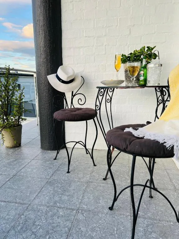 Outdoor seating area with decorative iron chairs and water view beyond