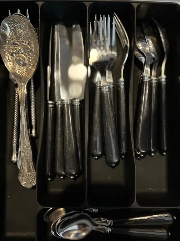 Elegant silverware set organized in black drawer compartments