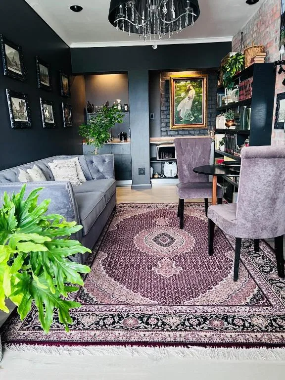 Stylish living room with gray sofa, purple armchair, and dark accent walls