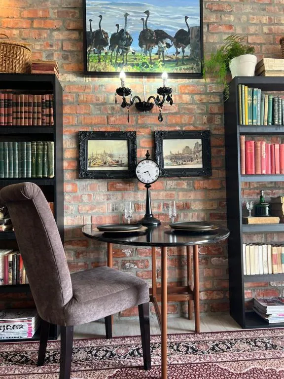 Elegant lounge with brick fireplace, bookshelves, and decorative details