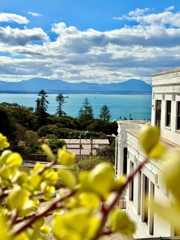 Turquoise bay and mountains visible from property with flowering plants