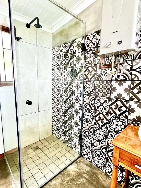 Modern bathroom with patterned tiles and glass-enclosed shower stall