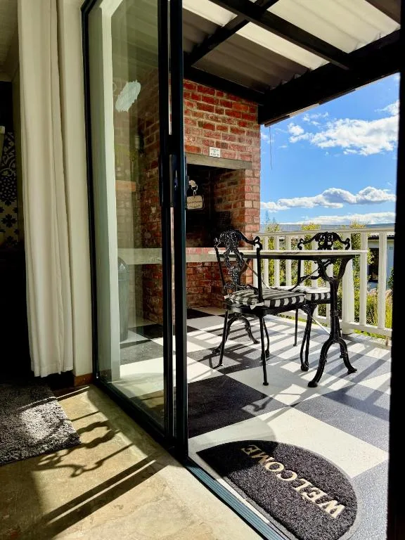 Outdoor deck with black metal chairs overlooking scenic landscape views