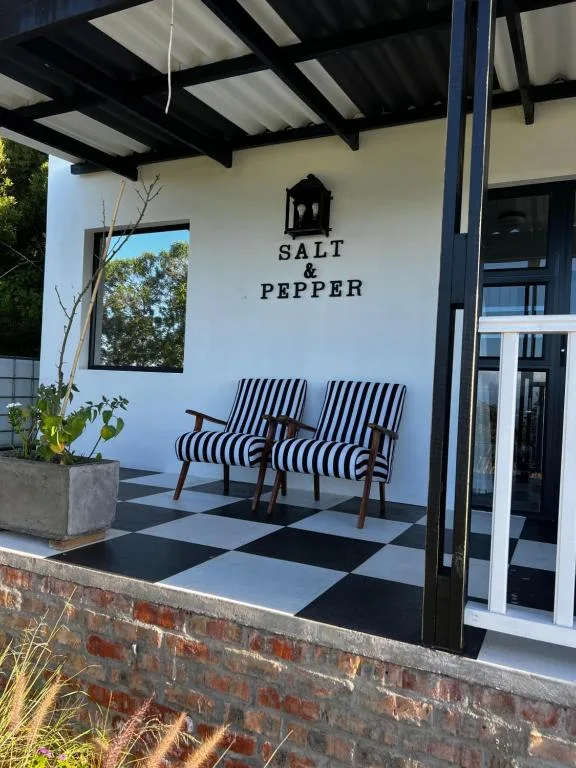 Covered patio with striped chairs and checkered floor at Salt and Pepper