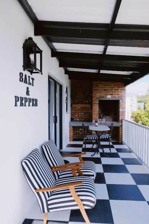 Covered patio with striped chairs and checkered floor at Salt & Pepper