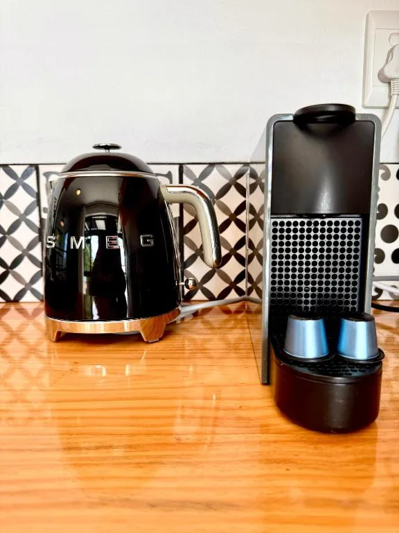 Modern black SMEG kettle and coffee machine on wooden countertop