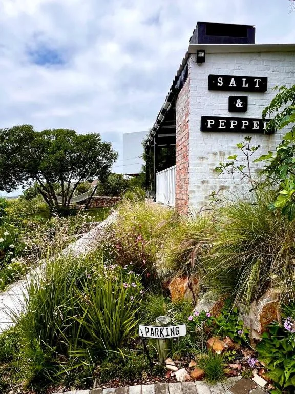 White brick building with Salt & Pepper signage and native garden landscaping