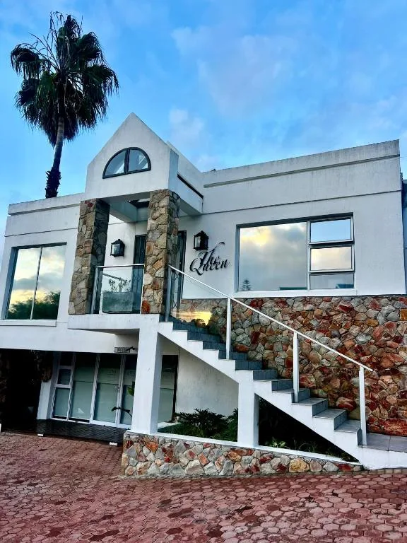 Modern white apartment building with stone accents and palm tree entrance
