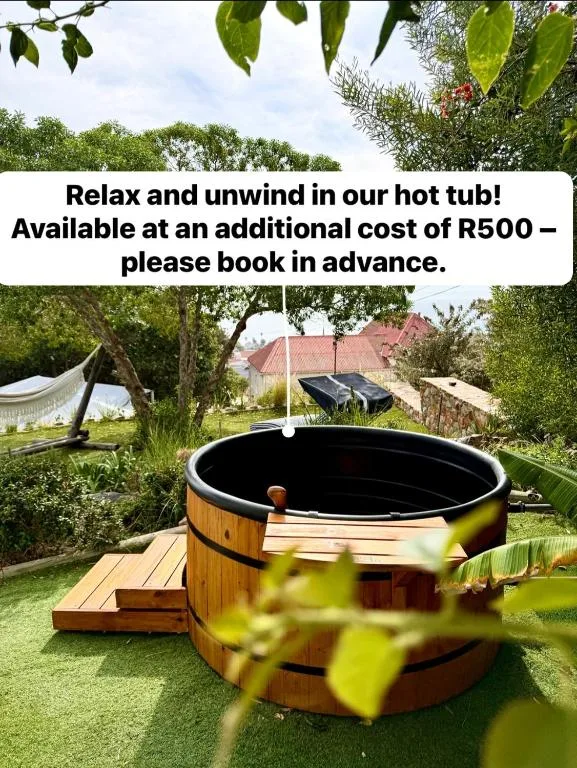 Wooden hot tub with black interior in lush garden setting