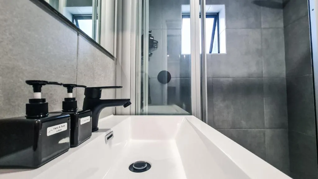Modern bathroom with white soaking tub and frameless glass shower enclosure