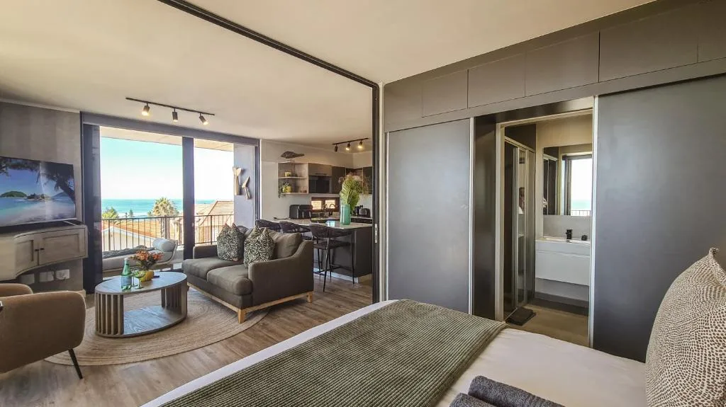 Spacious bedroom with ocean view balcony access and ensuite bathroom