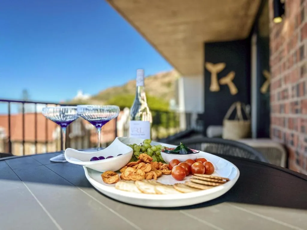 Outdoor deck with charcuterie platter, wine glasses, and mountain views