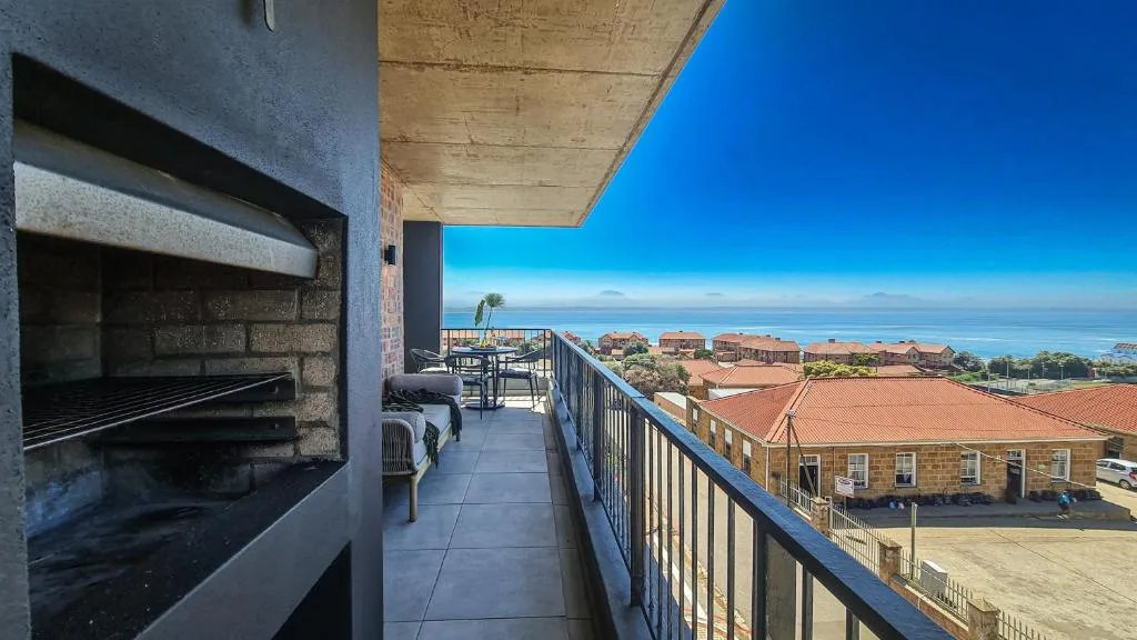 Elevated deck with braai area overlooking coastal town and ocean horizon