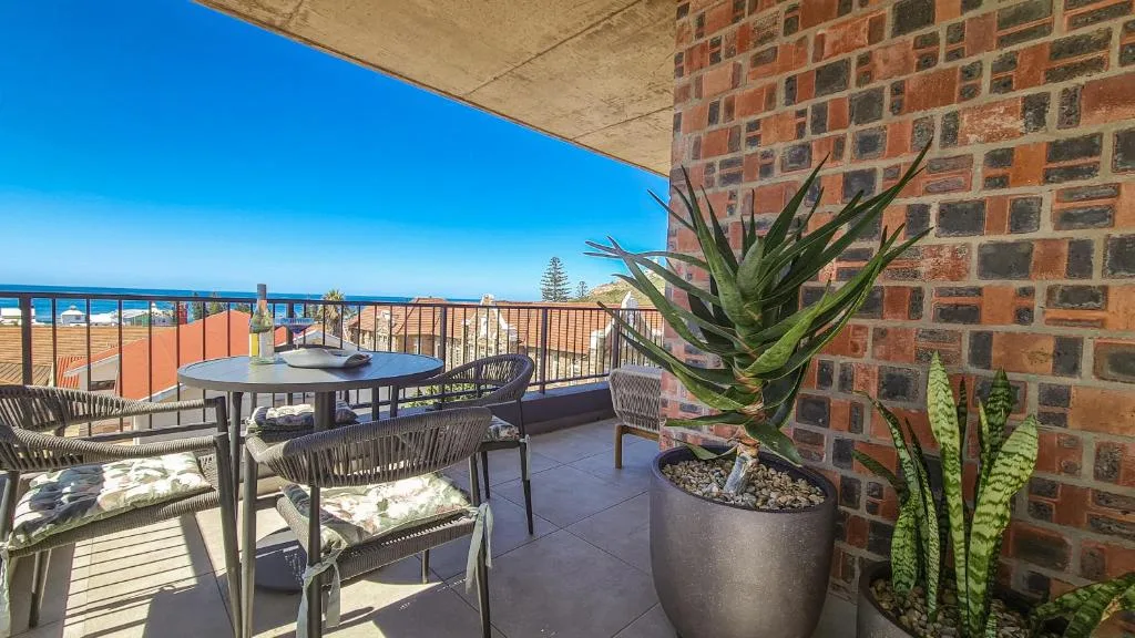 Spacious rooftop deck with ocean views, seating area, potted succulents
