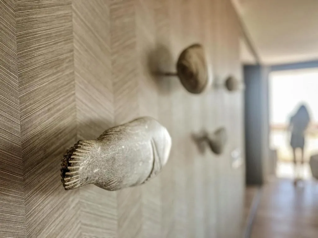 Close-up of decorative shell-shaped door handle on textured wall