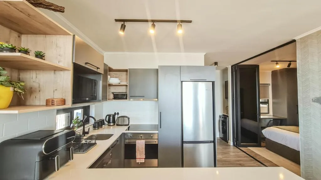 Modern kitchen with stainless steel appliances and wooden shelving